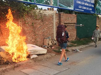 Frau mit Vaude AStrum Rucksack läuft an einem Feuer vorbei