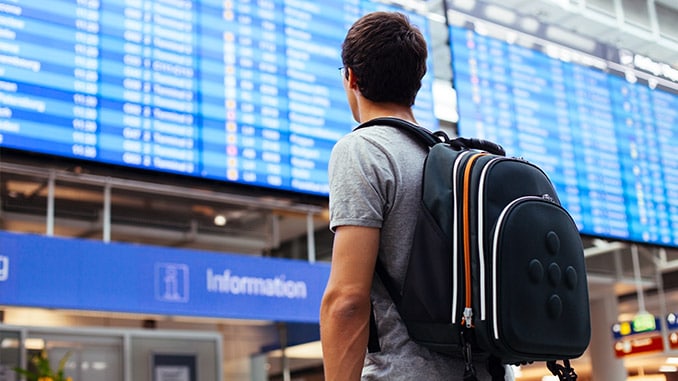 Mann mit Rucksack am Flughafen